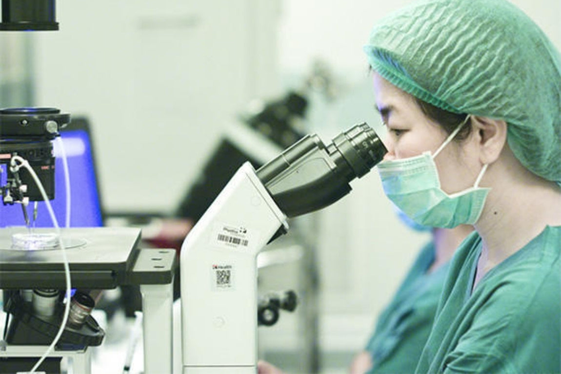 scientist checking t-cell activator in microscope 
